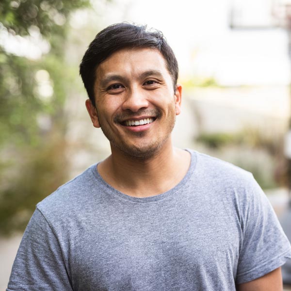 Hispanic adult standing outside and smiling