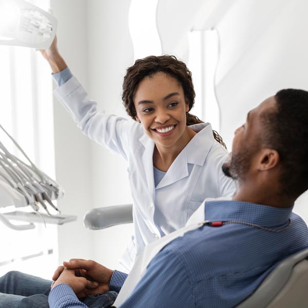 Female dentist greeting male patient at her workplace